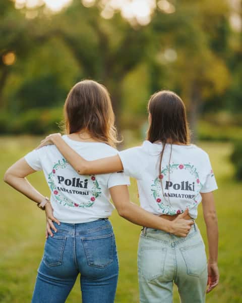 Dwie animatorki w koszulkach Polki Animatorki, widziane od tyłu